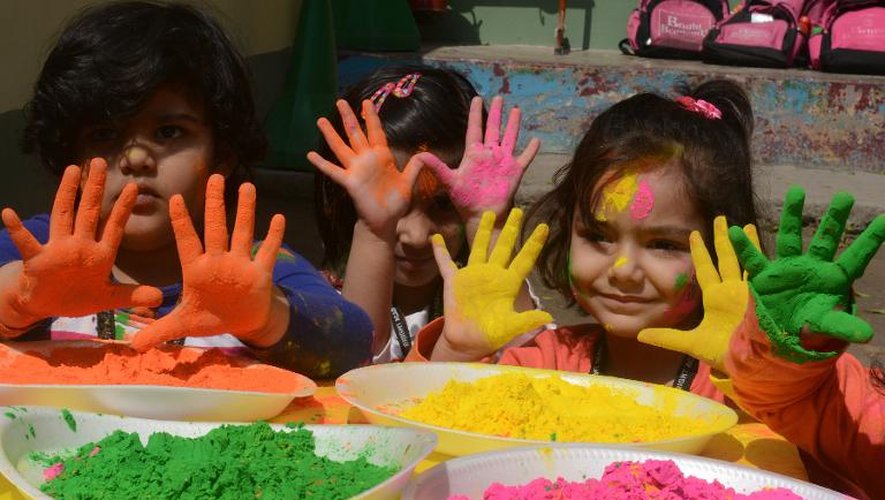Des enfants indiens posent avec des pigments de couleur, pendant les festivités d'Holi, le 4 mars 2015