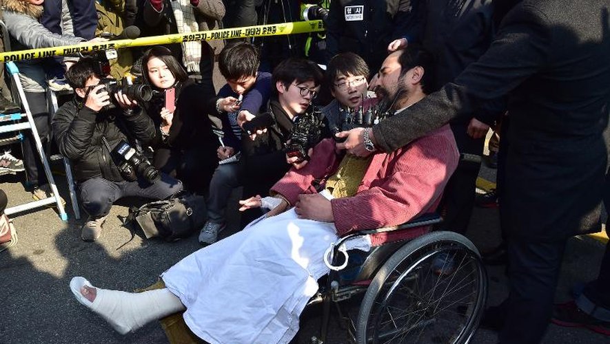 Kim Ki-Jong, auteur de l'attaque contre l'ambassadeur américain, est interrogé par des journalistes à la sortie d'un commissariat à Séoul, le 6 mars 2015