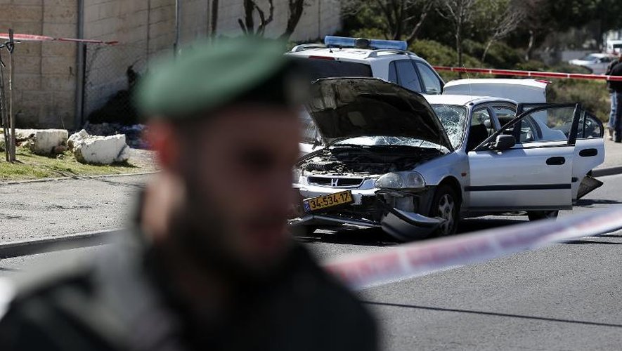 Un policier israélien devant la voiture bélier qui s'est précipitée sur des piétons à Jérusalem, faisant plusieurs blessés, le 6 mars 2015