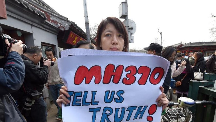 Une membre de la famille d'un passager chinois, disparu dans le vol MH370, tient une pancarte sur laquelle est écrit "Dites-nous la vérité!", alors qu'elle quitte un temple de Pékin après une prière le 8 mars 2015