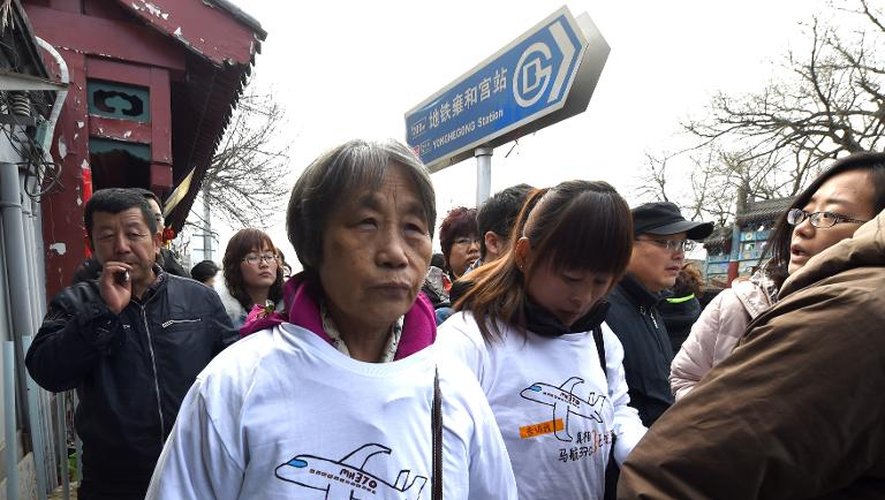 Des membres des familles des passagers chinois du vol MH370 quittent un temple de Pékin après une prière le 8 mars 2015
