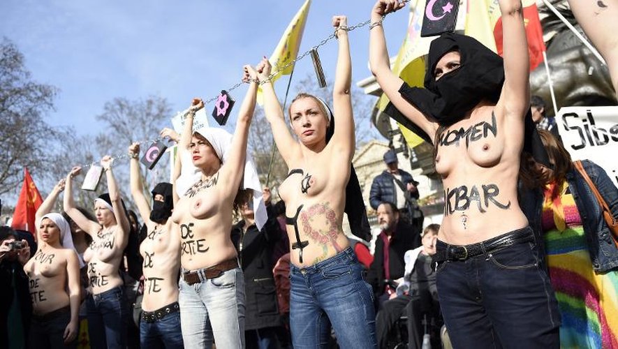 Des activistes féministes des "Femen" protestent, seins nus, lors de la Journée de la Femme le 8 mars 2015 à Paris, en se montrant symboliquement "enchaînées" par les religions