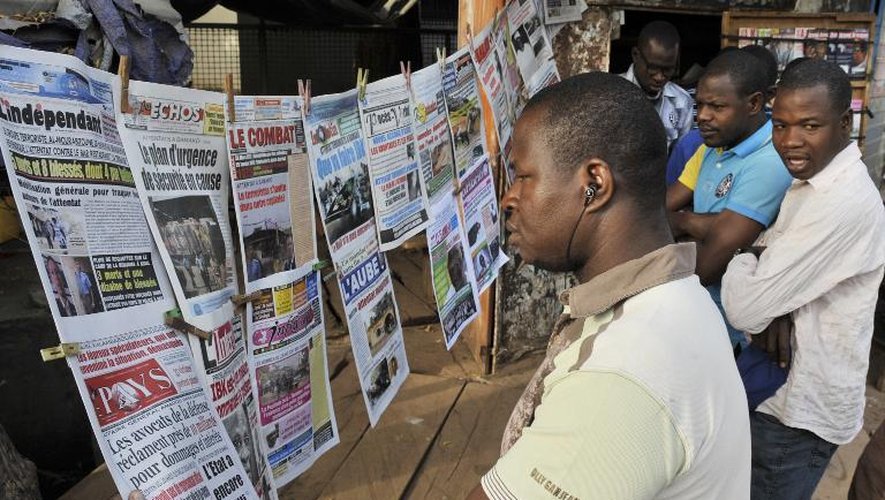 Des Maliens lisent les Unes des journaux à Bamako le 9 mars 2015