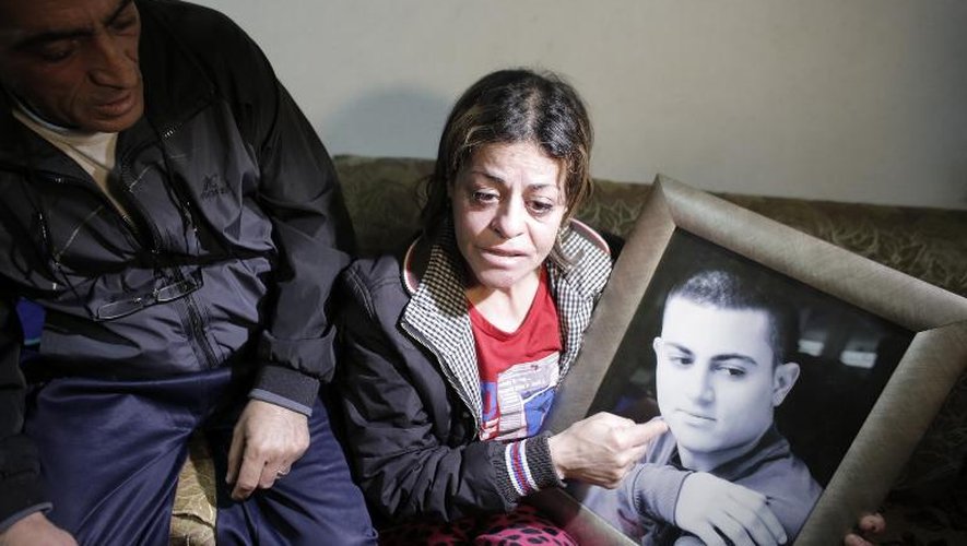 Les parents de Muhammad Said Ismail Musallam brandissent son portrait, un Arabe israélien dont l'EI revendique l'assassinat, le 10 mars 2015 à Jérusalem-Est