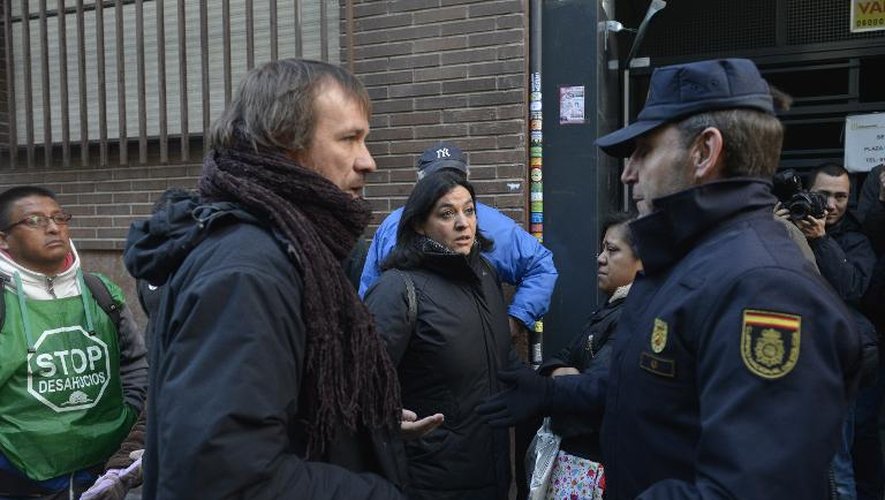Face à face entre des policiers espagnols et deux activistes du groupe anti-expulsion PAH, Manolo Beltran et Angeles Gracia Gonzalez, qui tentent d'empêcher le délogement de Jessica Bernice Michelena et sa famille, le 3 février 2015 à Madrid