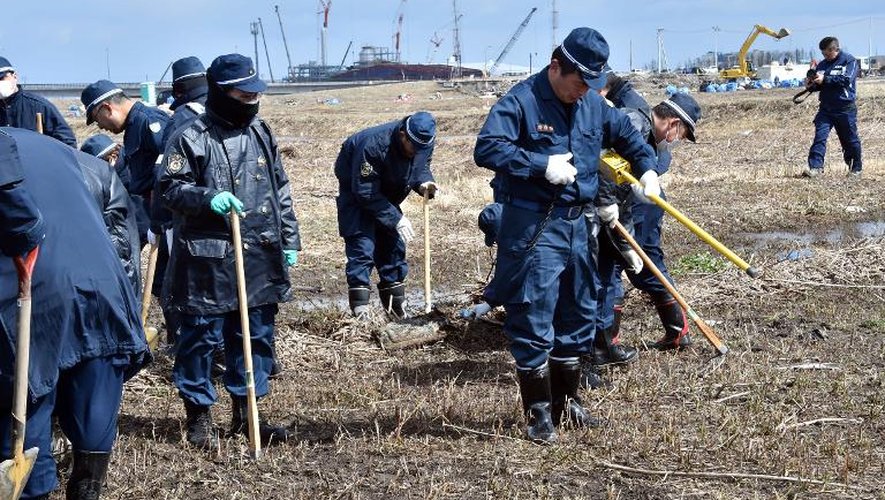 Des policiers continuent à chercher, le 11 mars 2015 près de la centrale de Fukushima des restes de personnes disparues il y a 4 ans