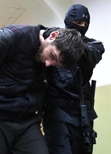 Zaour Dadaïev est tenu par un un policier au tribunal de Basmanny à Moscou, le 8 mars 2015