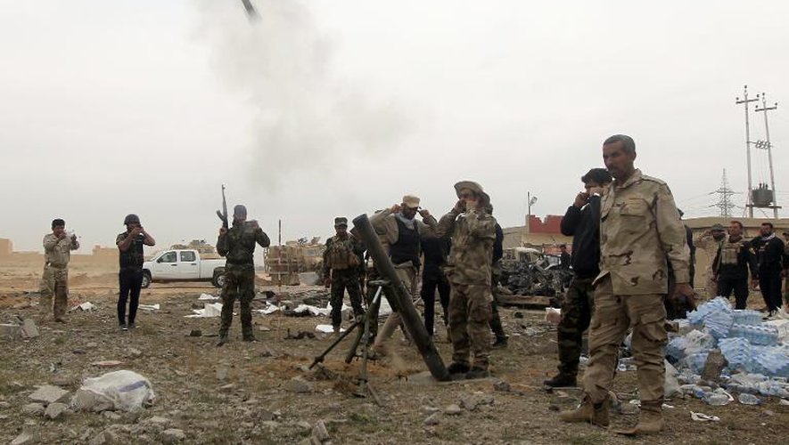 Des miliciens chiites lancent un obus de mortier vers des positions des jihadistes du groupe Etat islamique à Tikrit, 160 km au nord de Bagdad, le 12 mars 2015