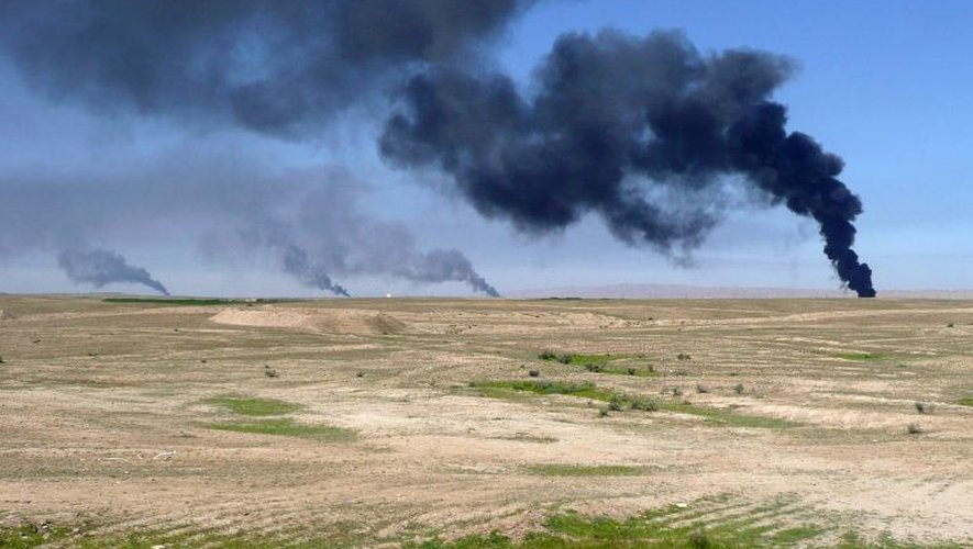 De la fumée s'élève d'un champ de pétrole qui aurait été incendié par le groupe EI au nord-est de Tikrit, en Irak, le 11 mars 2015