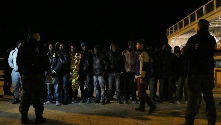 Des migrants débarquent sur le port d'Augusta en Sicile, le 4 mars 2015 d'un bateau arraisonné par les garde-côtes italiens