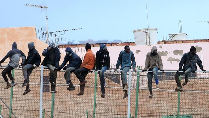 Des migrants illégaux en train de franchir un grillage à Melilla, une enclave espagnol en Afrique du nord, le 19 février 2015