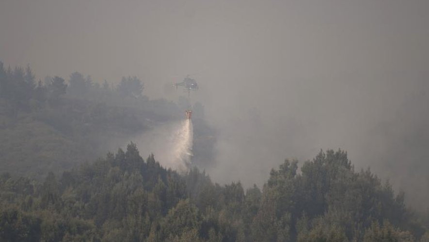 Un hélicoptère lutte contre un gigantesque incendie dans le secteur de Agua Santa, à Valparaiso, au Chili le 14 mars 2015