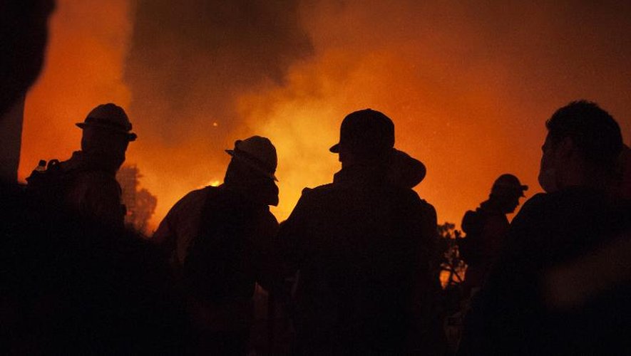 Des pompiers luttent contre un gigantesque incendie dans le quartier de Roderillo à Valparaiso le 13 mars 2015