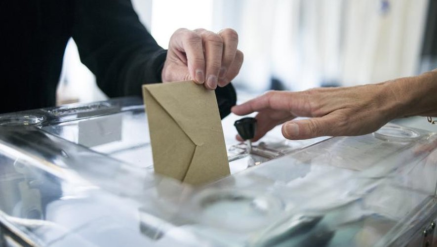 Un électeur dépose son bulletin dans l'urne le 25 mai 2014 dans un bureau de vote à Saint-Cloud