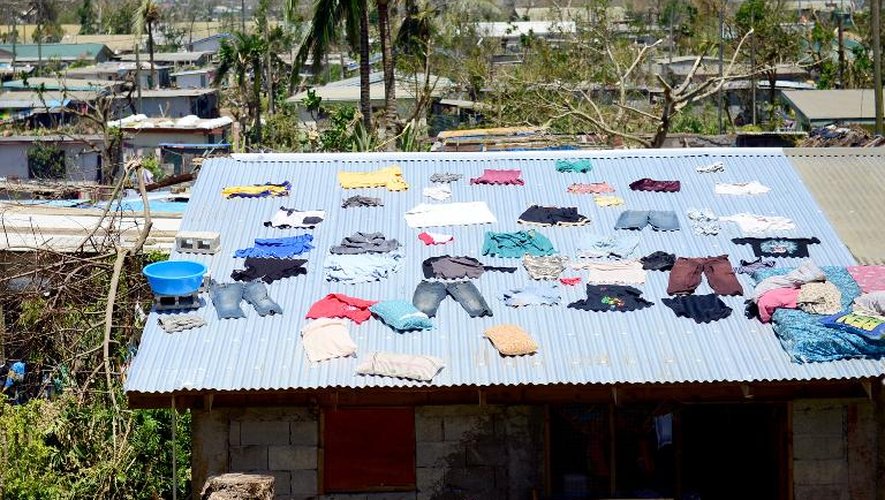 Des habitants font sécher leurs vêtements sur le toit d'une maison après le passage du cyclone Pam à Port-Vila, capitale du Vanuatu, le 17 mars 2015