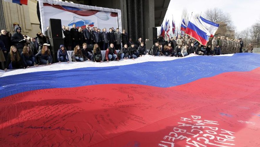 Des manifestants déploient un drapeau russe géant avec l'inscription: "La Crimée et la Russie, ensemble pour toujours", le 16 mars 2015 dans la ville de Simferopol