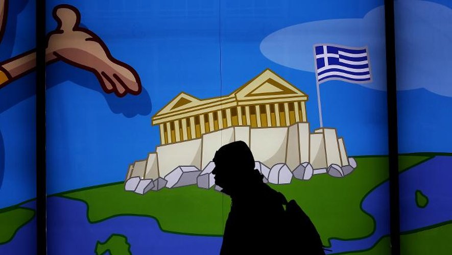 Un homme passe devant une devanture représentant l'Acropole, le 14 mars 2015, à Athènes