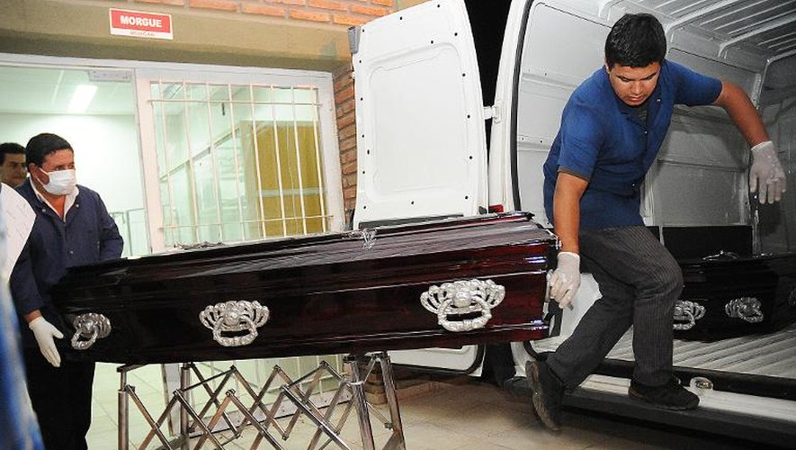 Des employés des pompes funèbres portent le cercueil d'un des huit Français morts dans le crash de leur hélicoptère pendant le tournage d'une émission télévisée en Argentine, le 17 mars 2015 à La Rioja, dans le nord-ouest du pays