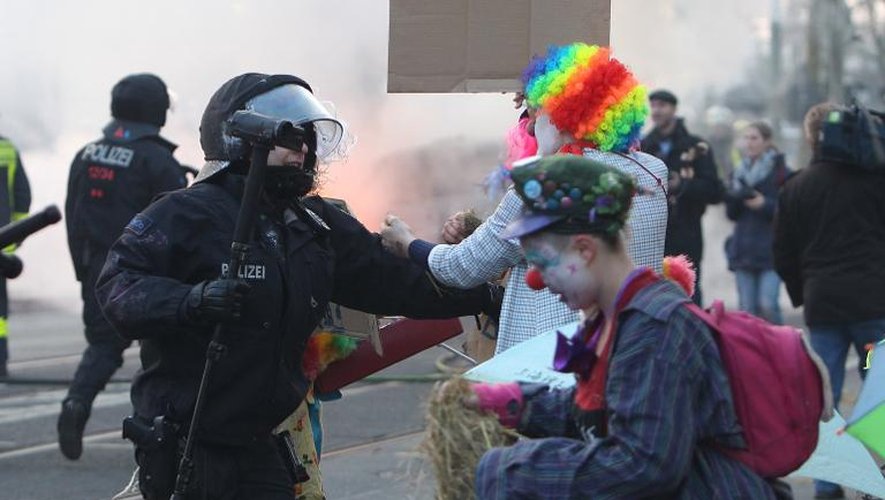 Des policiers allemands font face à des manifestants anti-austérité déguisés en clowns, le 18 mars 2015 à proximité du nouveau siège de la BCE à Francfort