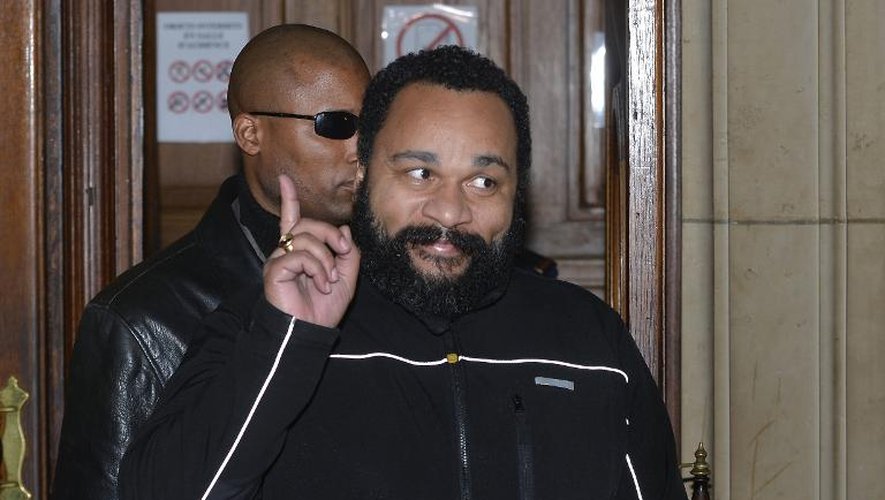 L'humoriste Dieudonné fait un signe à la sortie de l'audience du tribunal correctionnel de Paris où il est poursuivi pour apologie du terrorisme, le 4 février 2015