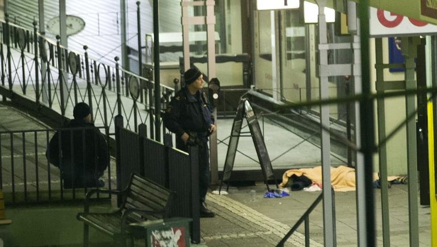 Des policiers près du corps de l'une des victimes de la fusillade commise le 18 mars 2015 devant un pub à Goteberg