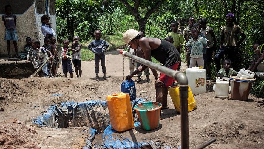 Des habitants de Kinshasa pompent de l'eau depuis le sol, le 7 mars 2015