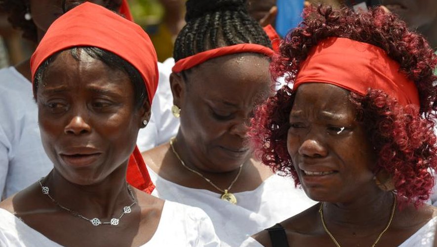 Des femmes pleurent des morts victimes du virus Ebola près de leurs tombes, le 7 mars 2015 à Monrovia