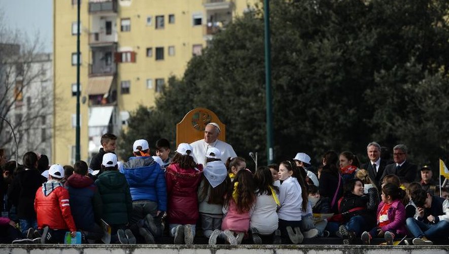 Des enfants entourent le pape François, le 21 mars 2015 à Scampia, un quartier défavorisé de Naples affecté par les plaies du chômage et de la mafia