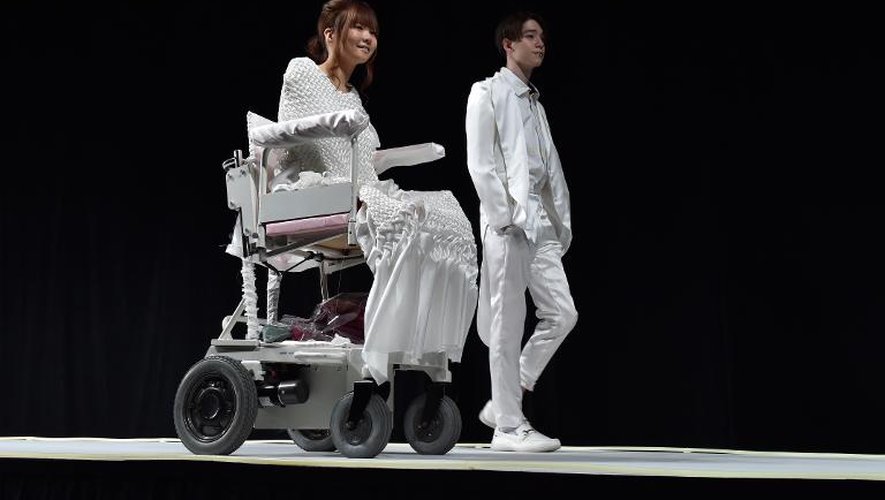 Ami Sano (g), atteinte d'une maladie rare qui l'a laissée sans membres, répète aux côtés d'un mannequin pour un défilé du créateur Takafumi Tsuruta pendant la Semaine de la mode de Tokyo