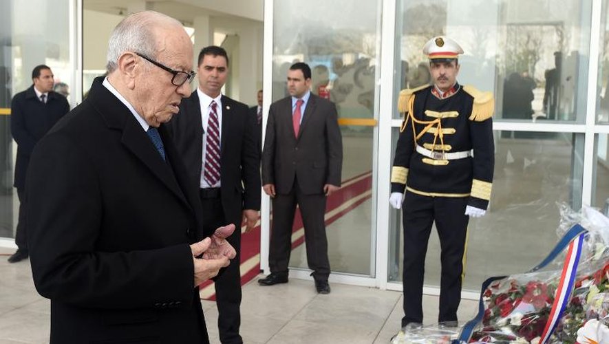 Le président tunisien Beji Caid Essebsi prie le 22 mars 2015 à l'entrée du Musée du Bardo de Tunis, après avoir y déposé une couronne de fleurs en hommage aux victimes de l'attentat qui a fait 21 morts, dont 20 touristes