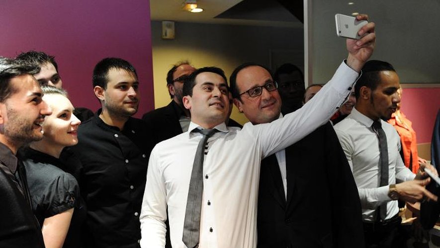 Le président François Hollande fait un selfie avec les salariés d'un restaurant à Tulle, le 22 mars 2015, jour du 1er tour des départementales