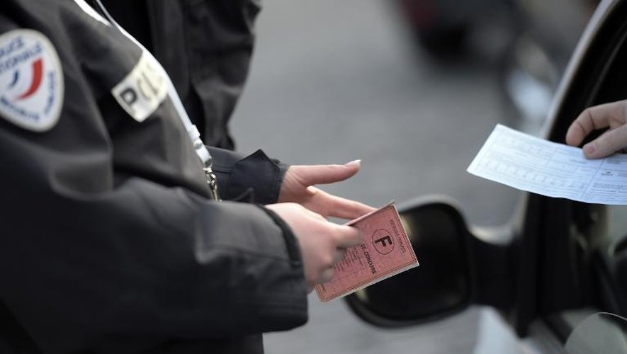 Un policier contôle un automobiliste le 23 mars 2015 à Paris où la circulation alternée est entrée en vigueur