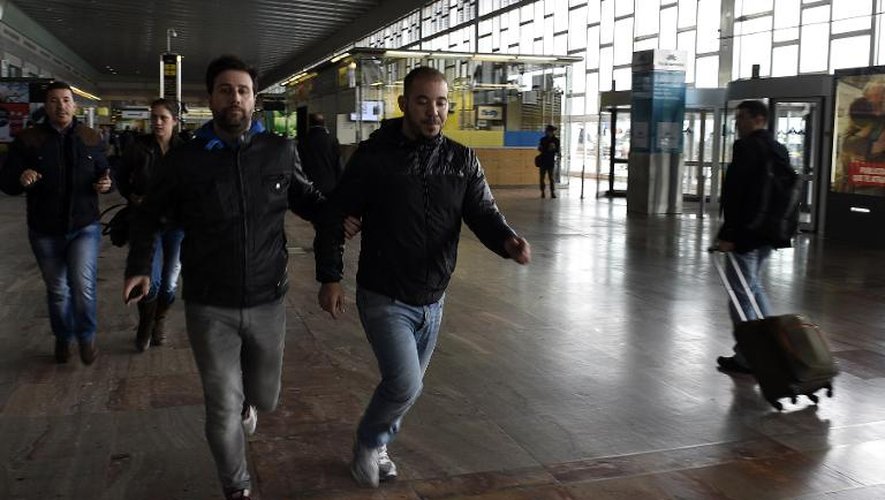 A l'aéroport de Barcelone, un policier escorte mardi un proche d'une victime du crash.