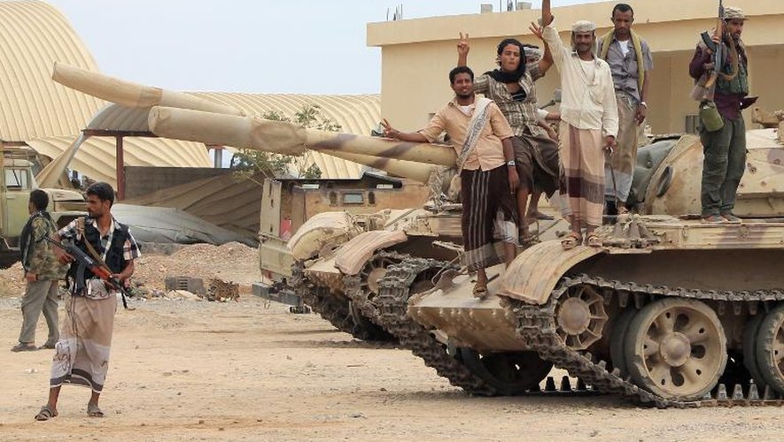 Des combattants opposés aux Houthis font le signe de la victoire sur un tank à Lahj au Yemen, le 24 mars 2015