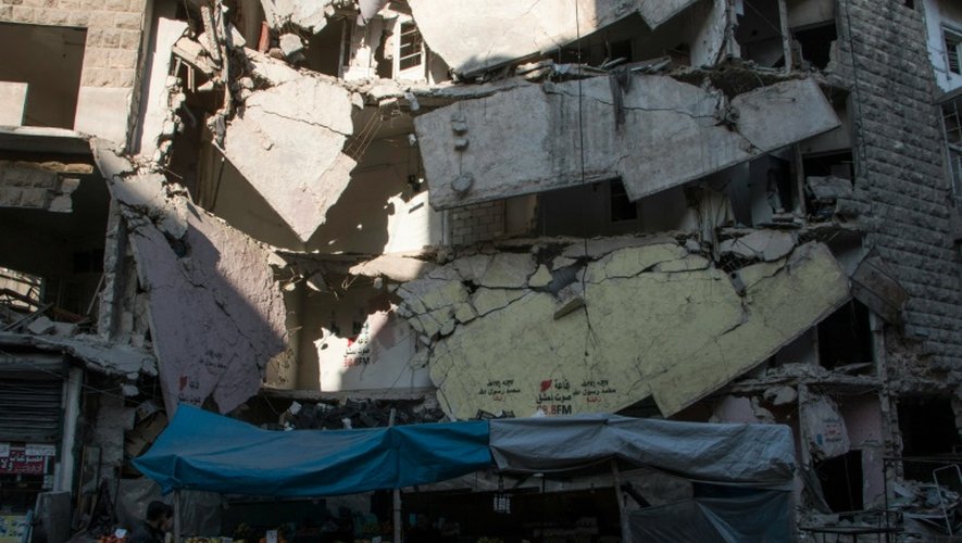 Un étalage de primeurs devant un immeuble détruit le 9 février 2016 à Alep