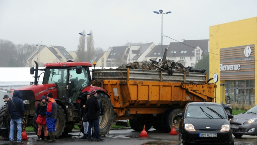 Des agriculteurs français bloquent l'accès à un hypermarché avec leurs tracteurs et leurs remorques chargées de déchets à Quimper, le 2 février 2016