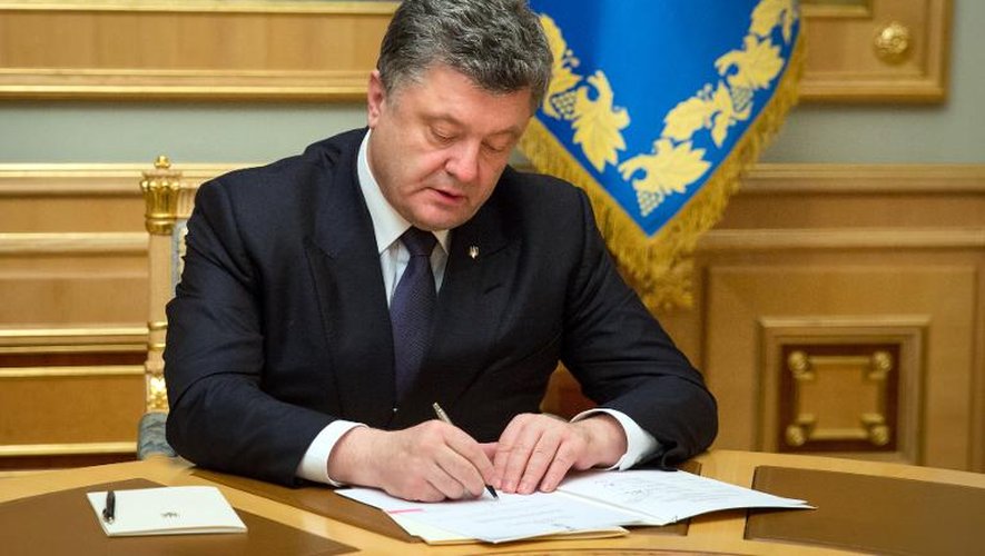 Photo diffusée par la présidence ukrainienne le 25 mars 2015 montrant le président Petro Porochenko en train de signer à Kiev la destitution d'un gouverneur