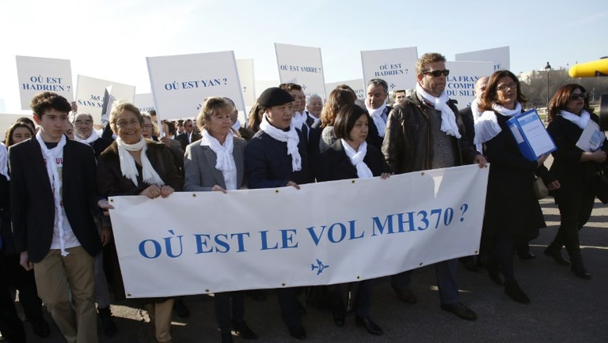 Ghyslain Wattrelos (3e à d), proche de victimes du vol MH370 de la Malaysia Airlines qui a disparu en mars 2014, en tête d'une marche silencieuse vers le Palais de l'Elysée à Paris, le 8 mars 2015