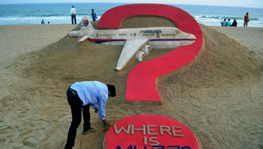 "Où est le MH370?", oeuvre de l'artiste indien Sudarsan Pattnaik (à gauche, au premier plan), sur une plage de Puri, en Inde, le 7 mars 2015