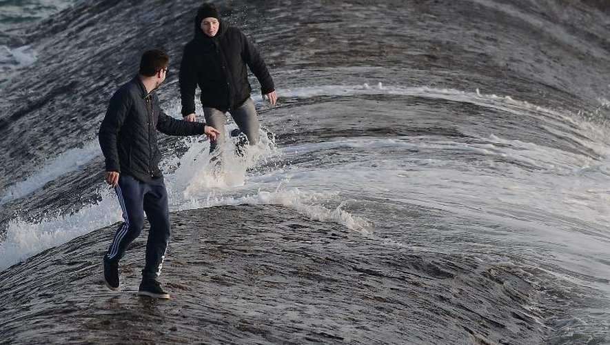 Des personnes montées sur la digue des Sables-d'Olonne pour regarder les vagues, lors de la "marée du siècle", le 21 mars 2015