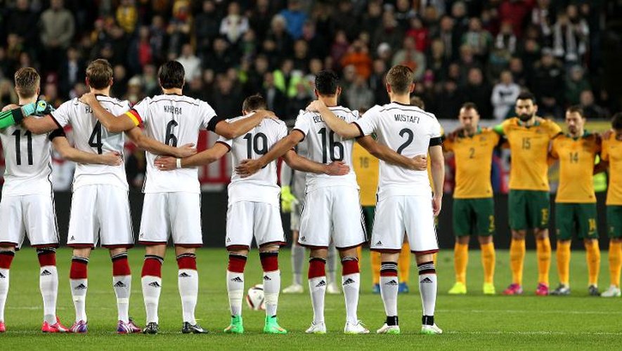 Les équipes d'Allemagne et d'Australie respectent une minute de silence en mémoire des 150 victimes du crash de l'Airbus A320, le 25 mars 2015 à Kaiserslautern
