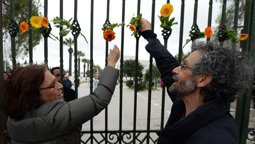 Des Tunisiens rendent hommage aux tués du musée du Bardo, devant les grilles du bâtiment à Tunis, le 24 mars 2015