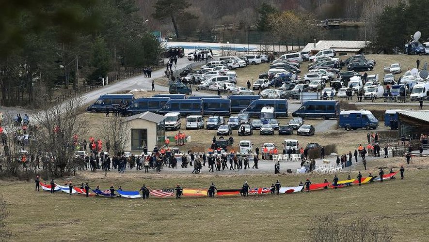 Les familles des victimes arrivent dans le village du Vernet, non loin du site du crash de l'A320 de Germanwings, alors que des secouristes ont déployé les drapeaux des nationalités des passagers, le 26 mars 2015