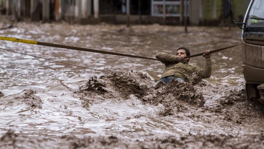 Un homme tente de traverser une rue inondée de Copiapo, au Chili, le 26 mars 2015
