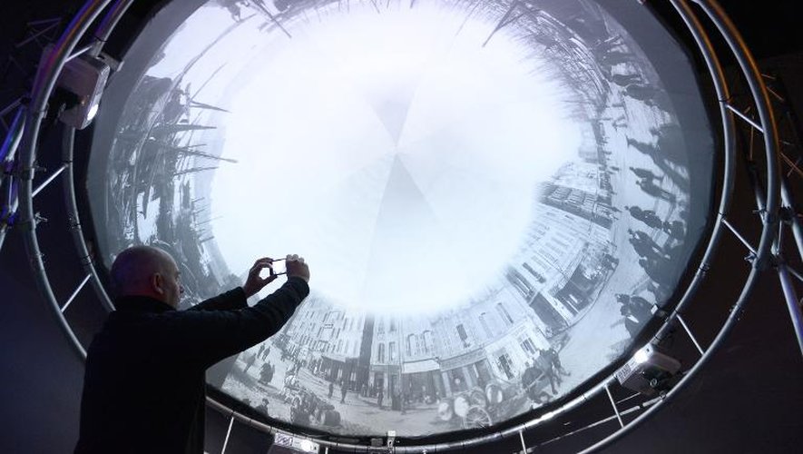 Un homme photographie le "Photorama" des frères Lumière à l'exposition "Lumière! Le cinéma inventé", le 25 mars 2015 au Grand Palais à Paris