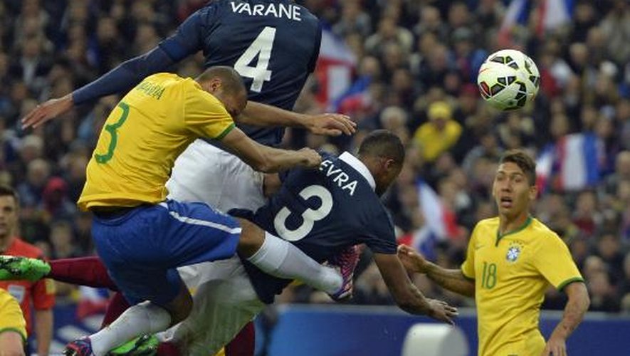 Le défenseur français Raphaël Varane marque de la tête contre le Brésil, en amical, le 26 mars 2015 au Stade de France