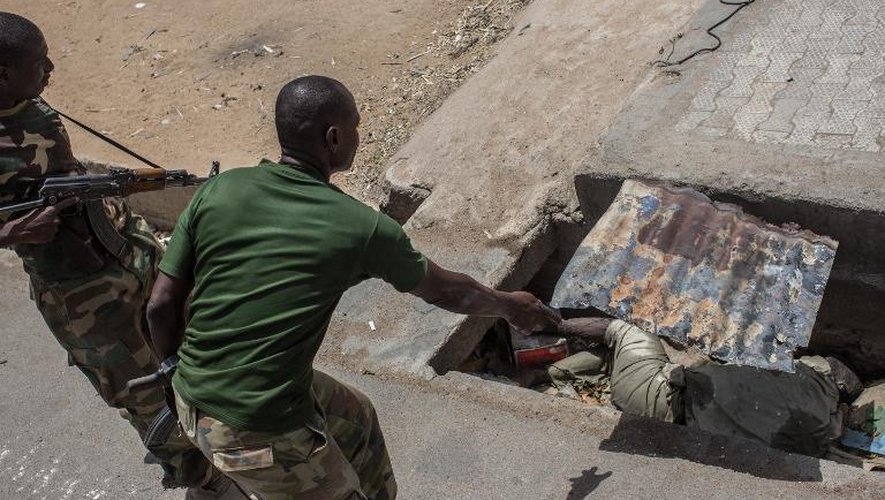 Un soldat nigérian découvre un cadavre en décomposition dans un égout dans la ville de Bama (nord du Nigéria), le 25 mars 2015