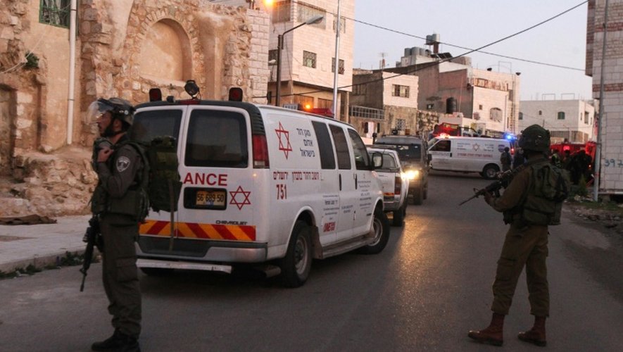 Des ambulances et des membres des forces de sécurité israéliennes, le 14 février 2016 à Hébron en Cisjordanie