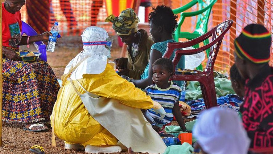 Un employé de Médecins sans frontières (MSF) nourrit un enfant victime du virus Ebola, le 15 août 2014 à Kailahun, au Sierra Leone
