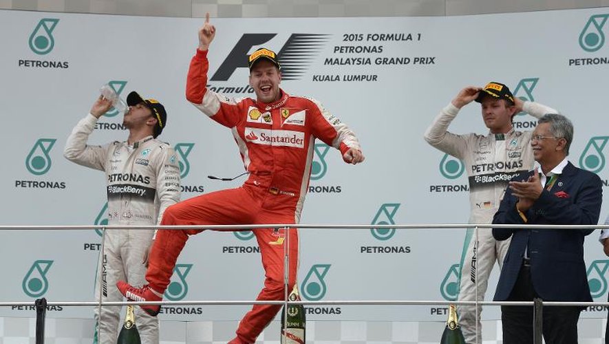 Le pilote allemand de Ferrari Sebastien Vettel (c) fête sa victoire au GP de Malaisie, le 29 mars 2015 à Sepang